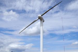 Wind turbine against a cloudy blue sky