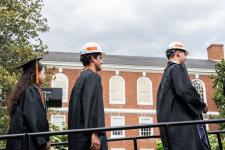 students wait to receive diplomas