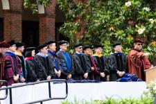 Faculty stand on stage