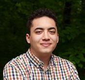 Image of man wearing checkered button up shirt smiling
