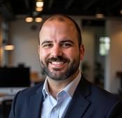 Image of man wearing navy blue jacket smiling