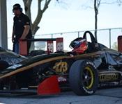 Image of man named Kevin wearing helmet inside a race car.