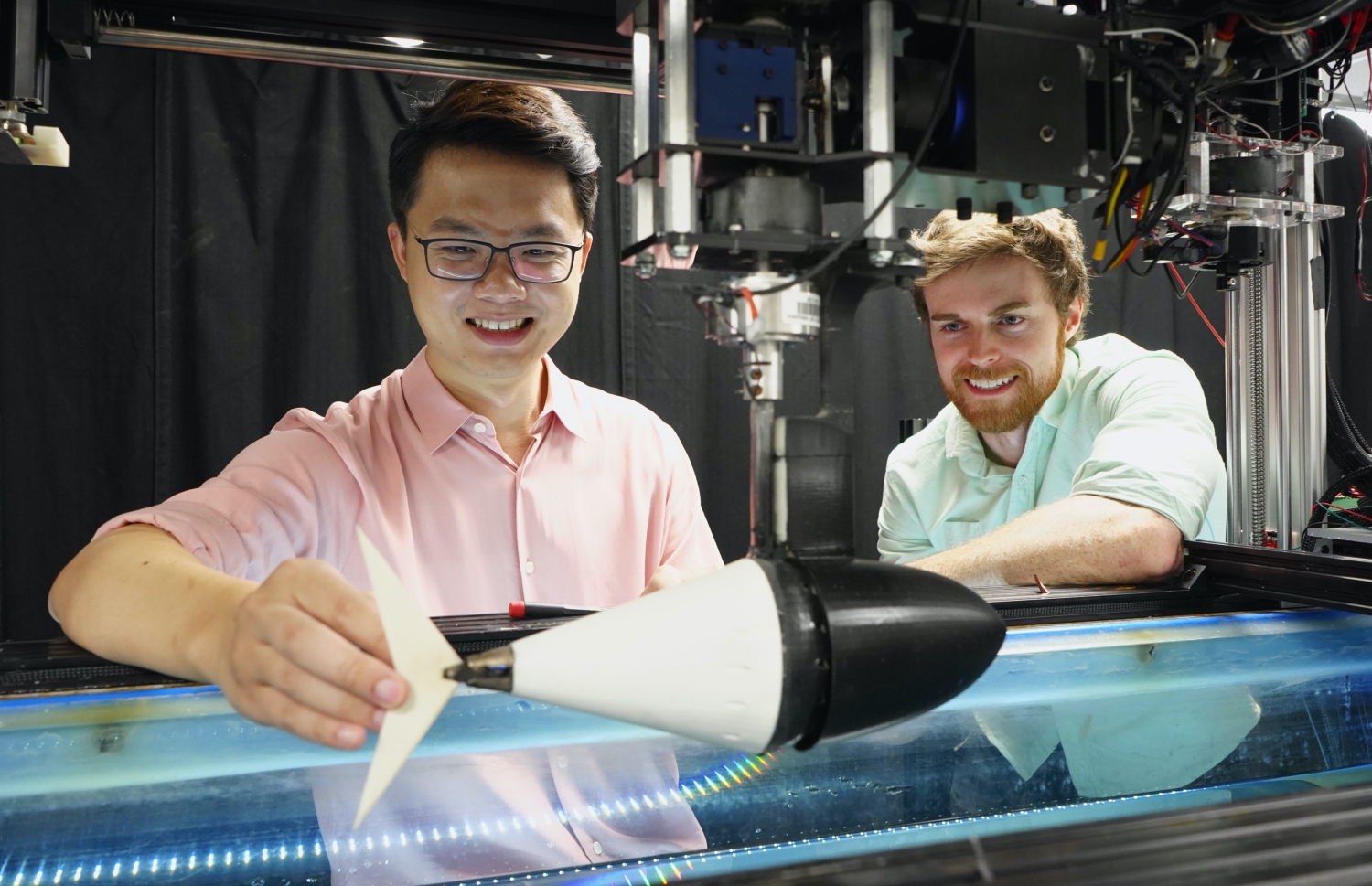 Quinn works with a graduate student in the lab to tune a robotic tuna's tail.