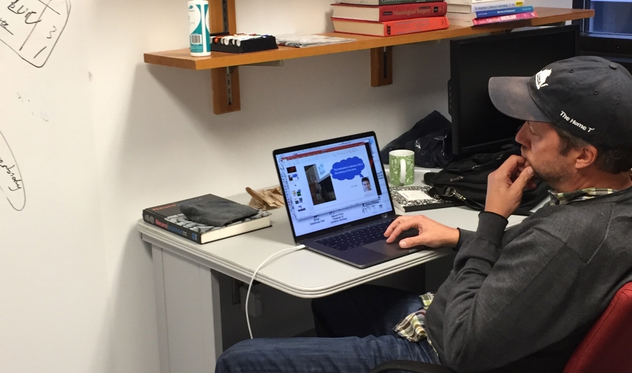 Scott Acton looks at a laptop