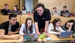 Professor interacting with students in computer science class
