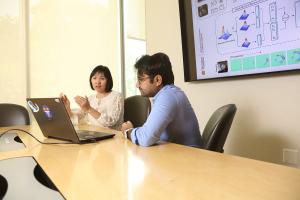 A student and professor confer over a laptop