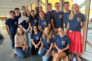 Image of Professor Shayn Peirce-Cottler standing with the 2024-2025 ME Students in a brightly lit walkway