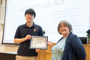 image of man receiving an award certificate from a female professor