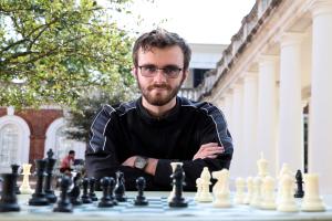 Portrait of a young man with a chess board in the foreground