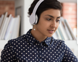 student in headphones listening to online course