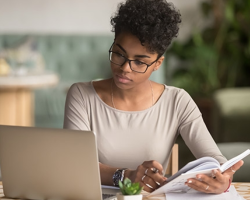student studying with laptop and book