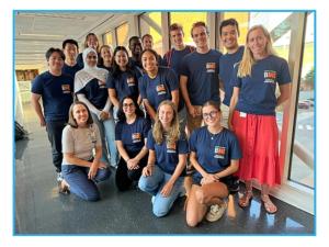 Image of Professor Shayn Peirce-Cottler standing with the 2024-2025 ME Students in a brightly lit walkway