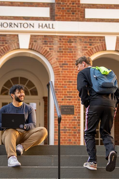 Two students greet each other outside of Thornton Hall