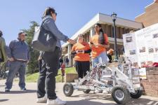 Students displaying the land rover they designed and built