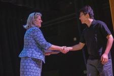 An award winner shakes Dean West's hand