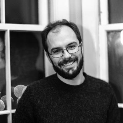 black and white image of man wearing glasses smiling