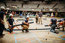 The whole group of students work together in an image showing the span of the bridge.